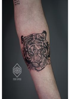 a black and white tiger tattoo on the left arm with geometrical shapes around it