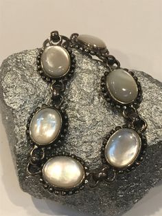 "Thiis is a beautiful, vintage, genuine, handmade Mother of Pearl and sterling silver bracelet that is adjustable and can be worn at either 7 inches or 7 1/2 inches. The bracelet is 5/8\" in width and features 6 Mother of Pearl links that measure about 3/4\" by 5/8\" each. The Mother of Pearls are set in polished sterling silver bezels with sterling silver beading around them. The MOP is so pretty, almost has the look of a Cat's Eye. The bracelet is stamped 925 and weighs about 22.1 grams. Gorge Adjustable Oval Antique Silver Jewelry, Ornate Adjustable Bracelets For Anniversary, Adjustable Oval Sterling Silver Bracelet With Oyster Design, Adjustable Oval Sterling Silver Oyster Bracelet, Antique Sterling Silver Adjustable Bracelet, Silver Oval Bracelets For Collectors, Vintage Sterling Silver Bracelet Stamped 925, Adjustable Oval Sterling Silver Bracelet Nickel Free, Adjustable Vintage Sterling Silver Bracelet