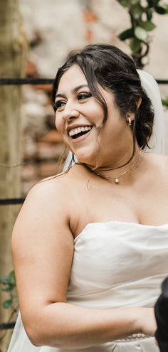 a woman in a wedding dress smiles at the camera