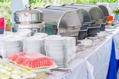 a buffet table with plates and watermelon slices on it