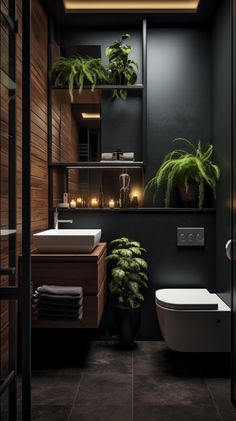 a bathroom with black walls and plants in the corner