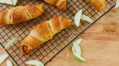 apple turnovers on a cooling rack with slices cut in half and apples scattered around them