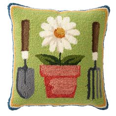 a green pillow with flowers and gardening utensils