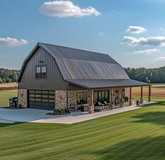 a large barn with a covered patio in the grass