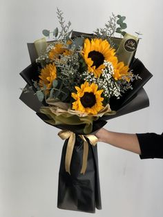 A Black Bouquet of Sunflowers Sunflower Flowers Bouquet, Flower Arrangement Bouquet, Sunflower Graduation Bouquet, Sunflower Creative Ideas, Aesthetic Sunflower Bouquet, Flower Bouquet Minimal, Bouquet For Man, Sunflower Bouquet Arrangement, Bouquet Sunflower Aesthetic