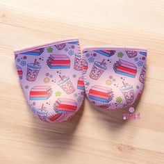 pair of pink slippers on wooden floor with pattern and colorful objects in the background