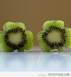 two pieces of kiwi fruit sitting on top of a table