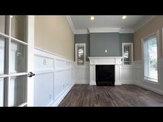 an empty living room with hard wood flooring and white trim on the fireplace mantel