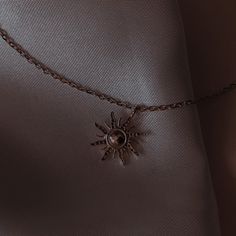 a necklace with a sun charm hanging from it's side