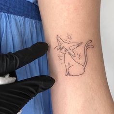 a woman's arm with a tattoo on it that has a cat drawn on it