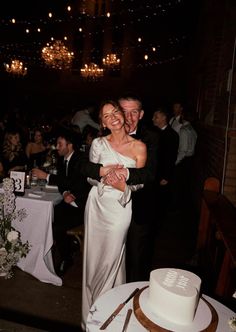 a bride and groom are hugging at their wedding reception