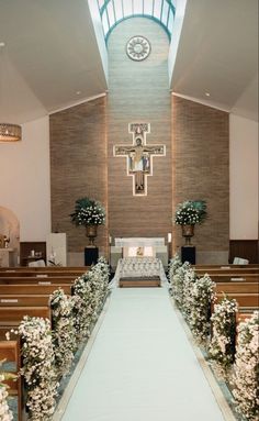 the aisle is decorated with white flowers and greenery