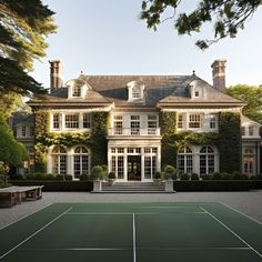 a tennis court in front of a large house