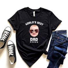 "Here's a beautifully printed custom baby face shirt for dad or grandpa. A high quality sublimation printing of your baby's face with the message \"World's Best Dad\". Definitely the perfect gift from wife to dad, kids to daddy, daughter to grandpa and so on. Our tees are super soft, best quality and sourced directly from the Bella Canvas manufacturer. Please note that these tees run large and it's best to size down for women. The printings / designs are done by third party professionals and shi Funny Character Print Tops For Father's Day, Father's Day Family Custom Print T-shirt, Father's Day Cotton T-shirt With Character Print, Fun Custom Print T-shirt For Father's Day, Funny Character Print T-shirt For Father's Day, Funny Custom Print T-shirt For Father's Day, Father's Day T-shirt With Character Print, Short Sleeve, Dad Baby, Custom Baby