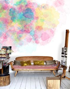 a living room filled with furniture next to a painting on the wall and wooden floors