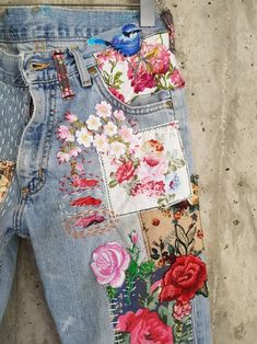 a pair of jeans with flowers and birds on them