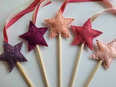 four star shaped lollipop sticks with pink, purple and red stars on them