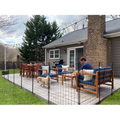 a man sitting at a table with his dog on the back deck in front of him