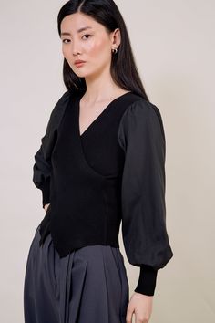 Our black contrast satin sleeved top brings glamour and comfort together. The luxurious satin balloon sleeves add elegance while the ribbed bodice offers the most flattering fit. Carefully designed the hem of this top matches the V-neck for an effortlessly chic look. - Satin balloon sleeves - Black V-neck top - Long sleeve - Cross panel top Elegant V-neck Tops With Sheer Sleeves, Fall Party Puff Sleeve V-neck Top, Fall V-neck Top With Sheer Sleeves, Elegant Stretch V-neck Top For Fall, Black V-neck Top For Workwear In Fall, Black V-neck Top For Fall Workwear, Fitted V-neck Top With Pleated Sleeves, Black V-neck Puff Sleeve Top For Fall, Chic Black V-neck Puff Sleeve Top