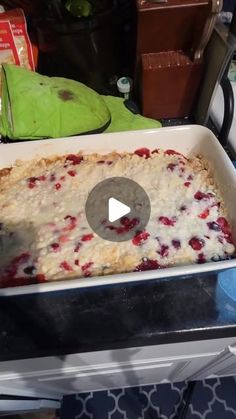 a pan filled with food sitting on top of a counter next to a green parrot