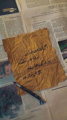 a piece of paper with arabic writing on it and a pen resting on top of it