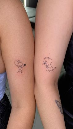 two people with matching tattoos on their legs, one has a small dog and the other has a bee