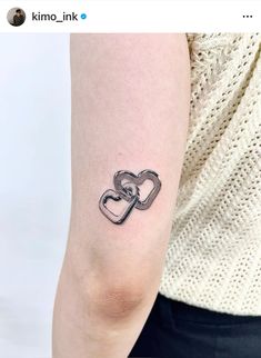 a woman's arm with two intertwined hearts on it