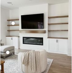 a large flat screen tv mounted on the wall above a fireplace