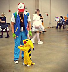 a man in a costume standing next to a small child dressed as pikachu