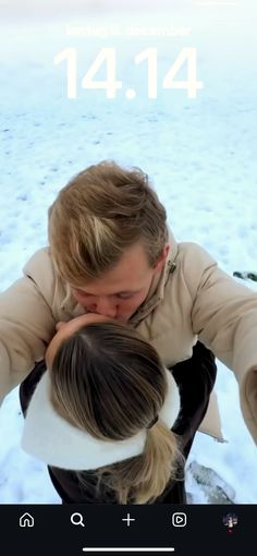 a man and woman hugging each other in front of the camera with snow on the ground