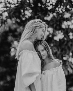 two women standing next to each other in black and white