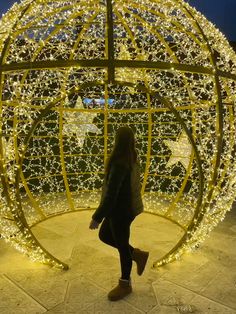 a woman standing in front of a lighted ball