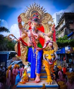 a statue of the god ganesh in front of a group of people on a city street