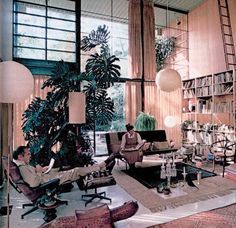 a living room filled with furniture and bookshelves next to a large open window