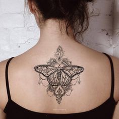 a woman with a butterfly tattoo on her back