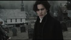 a man standing in front of a cemetery