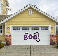 a garage decorated with bats and the word boo on it's side in front of a house