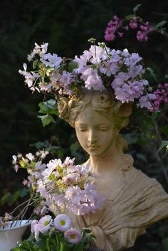 a statue with flowers in it's head and some plants growing out of it