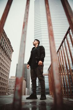 a man standing on top of a roof next to tall buildings