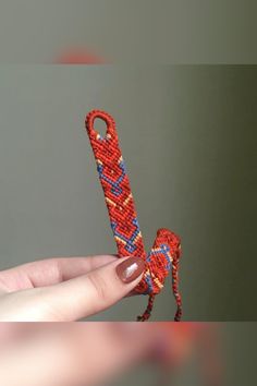 a hand holding a beaded object in the shape of a person's foot