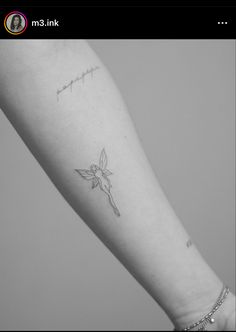 a small tattoo on the arm of a woman's left arm, with an arrow