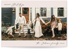 a family holding hands and walking in front of a house with the words happy holidays on it