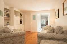 a living room with two couches and a book case in it's corner