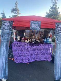 a purple table with skulls on it under a red tent