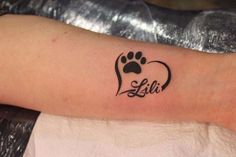 a dog paw and heart tattoo on the left arm for someone's love story