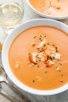 two white bowls filled with soup and garnished with scallops on top