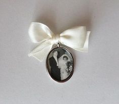 a white ribbon is attached to an old fashioned photo ornament with a bride and groom on it