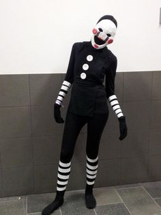 a creepy clown standing next to a wall in a room with tile floors and walls