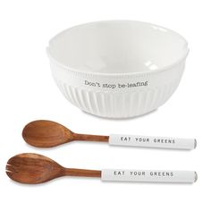 two wooden spoons and a white bowl with words on them