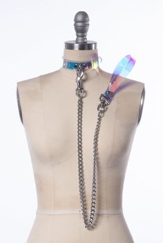 Magical, color-shifting iridescent choker collar made in thick PVC. Holographic, iridescent vinyl is layered over clear PVC. Features a d-ring in center front. Fit is adjustable with buckle in back. The leash clips on to the d-ring. The heavy-duty chain is 30" long, total length including the handle is 36" long. Collar is 1" wide. Silver toned hardware. SMALL/MEDIUM (11-13")MEDIUM/LARGE (13-15")LARGE/X-LARGE (15-17") Custom sizing available. All pieces are MADE TO ORDER, standard sizes S/M-L/XL. Holographic Iridescent, Gothic Choker, Pet Spaces, Gothic Chokers, Stunning Tops, Collars For Women, Choker Collar, Leather Pieces, Pastel Aesthetic